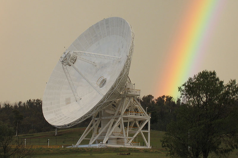 Angled view of DSS34 showing part of the support structure and a rainbow in the background