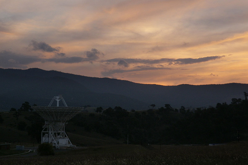 Deep Space Station 45 facing straight up with the hills in the background and sunset clouds