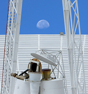 Feed horns, quad legs and dish of Deep Space Station 43 with the Moon