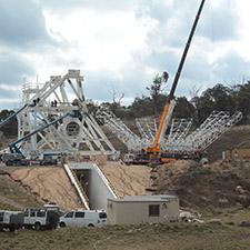 Part of the structure of the pedestal of the antenna with a partially built dish structure sitting beside it.
