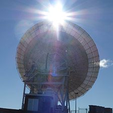 Deep Space Station 45 facing away with the Sun shining just above the top of it.