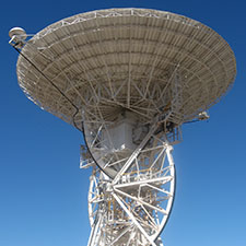 The antenna Deep Space Station 46 facing straight up with a very blue sky behind it.